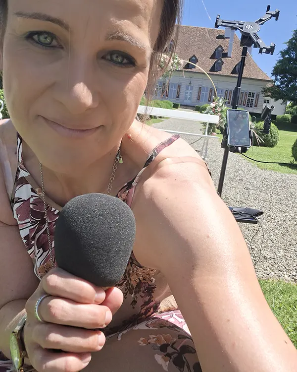 Hochzeitssängerin Lina Scholz mit Mikrofon vor Schloss Thunstetten während der Vorbereitungen auf eine freie Trauung.