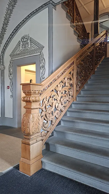 Historisches Treppenhaus im Landvogteischloss Willisau mit kunstvoll geschnitztem Holzgeländer.