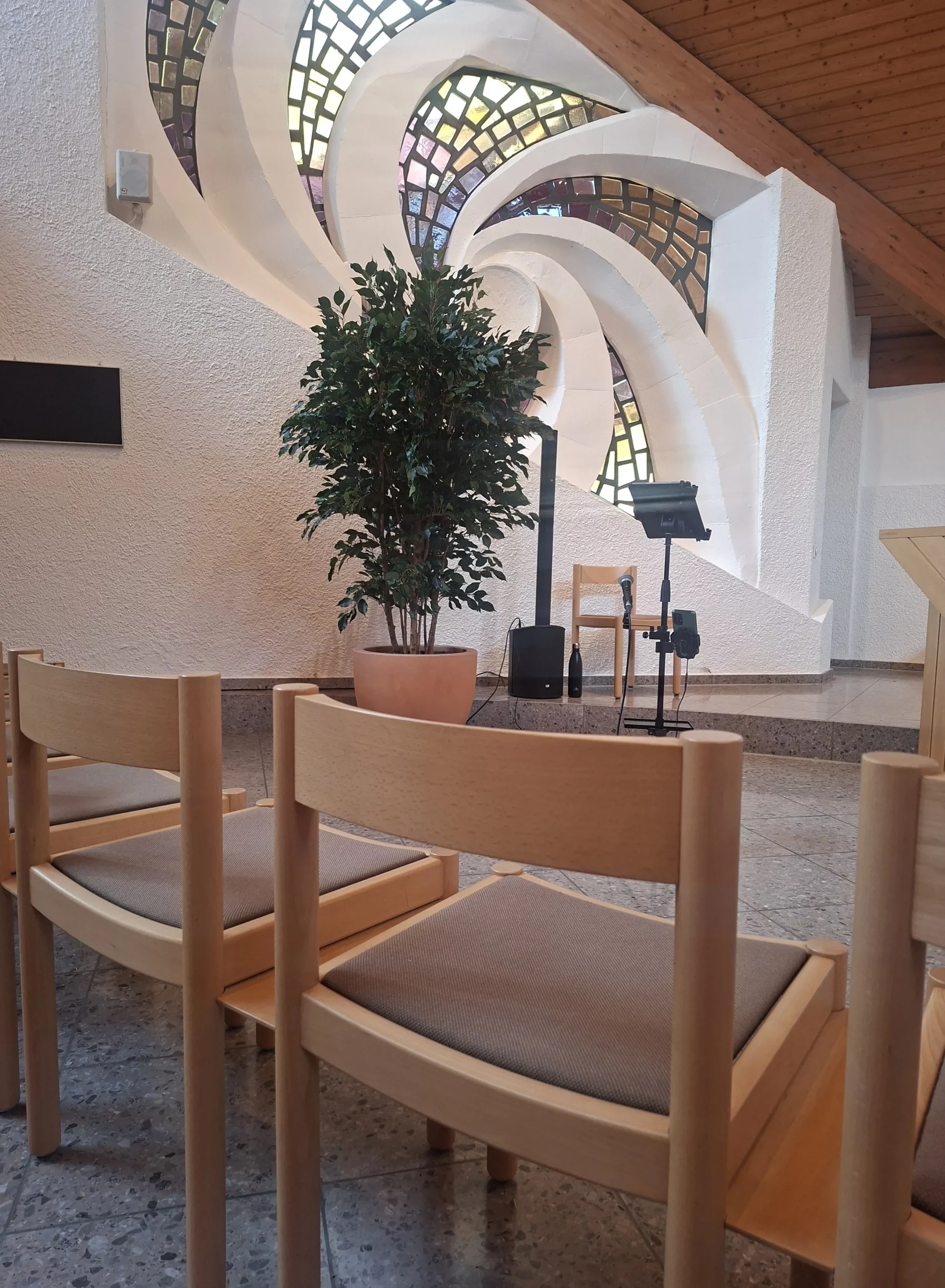 Geschwungene weisse Wandelemente mit farbigen Fenstern in der Abdankungskapelle Affoltern am Albis