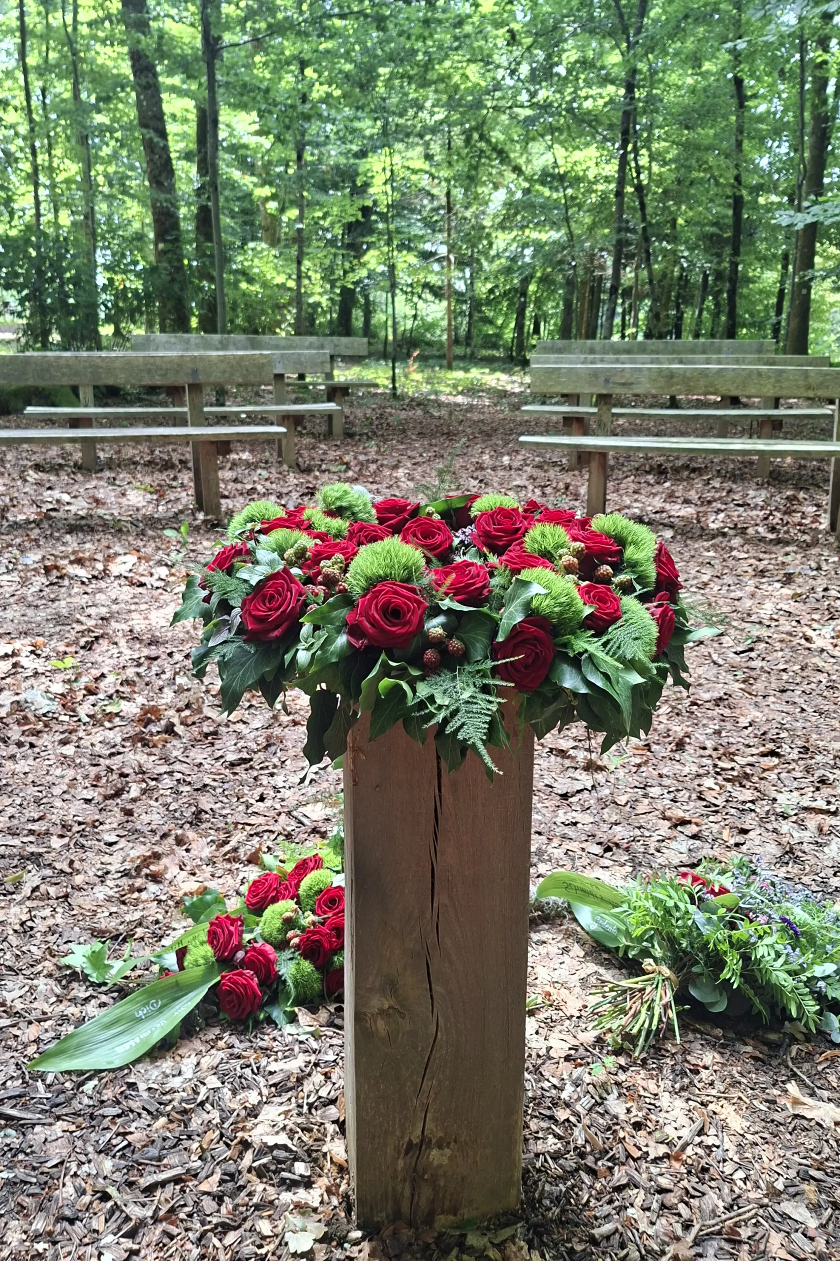 Blumenschmuck zur Trauerfeier auf einem Holzstamm im Ruhewald in Wehr