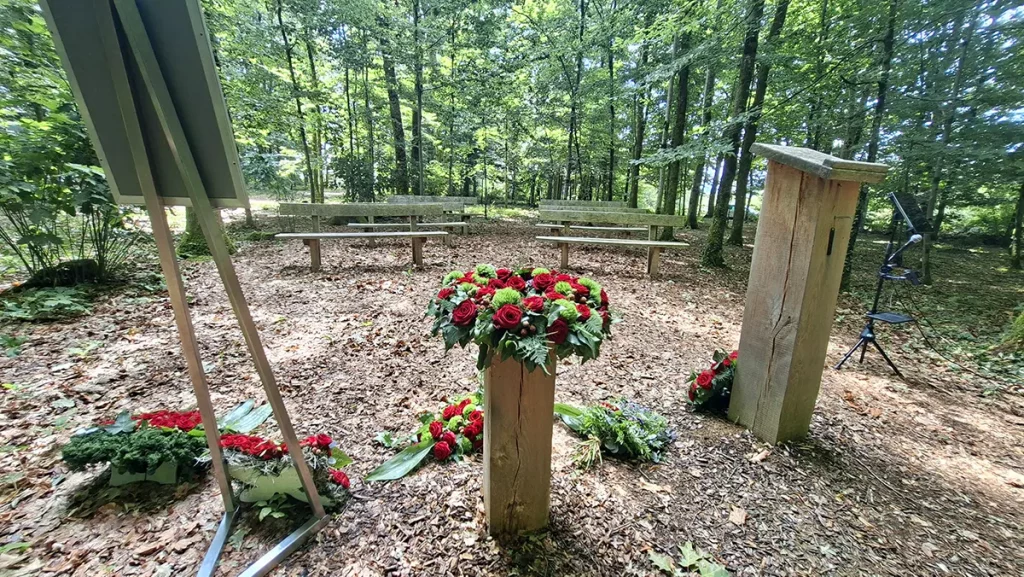 Trauerfeier im Ruhewald in Wehr mit Blumenschmuck und Sitzbänken mitten im Wald
